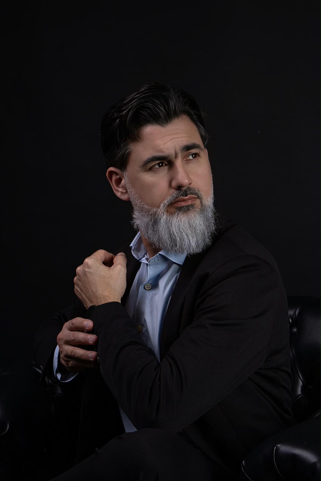 Hani Dufech sentado, olhando para o lado, em retrato executivo
